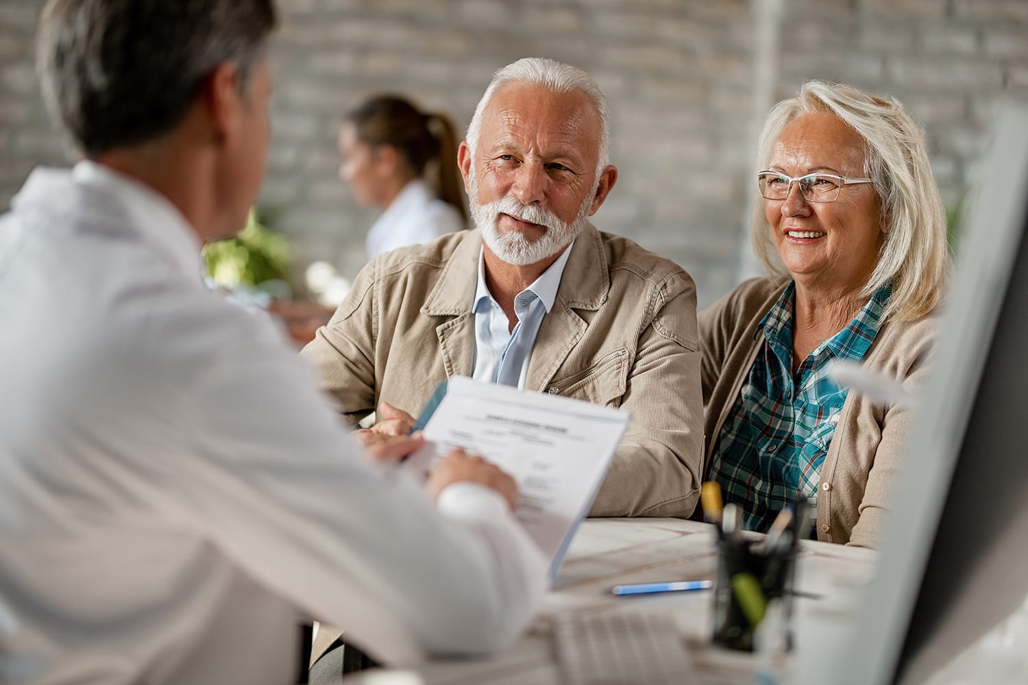 A senior couple reviewing their Medicare options with a Health Insurance Experts advisor